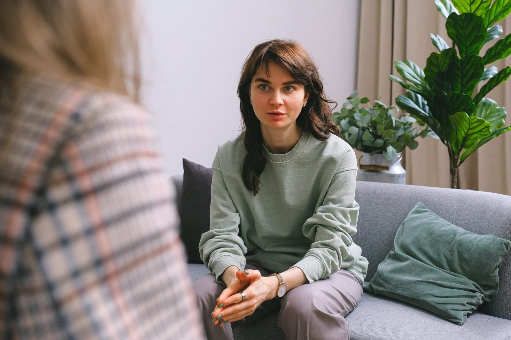 Mujer joven participando en una sesión terapéutica para abordar la depresión y recuperar el bienestar emocional en un entorno acogedor