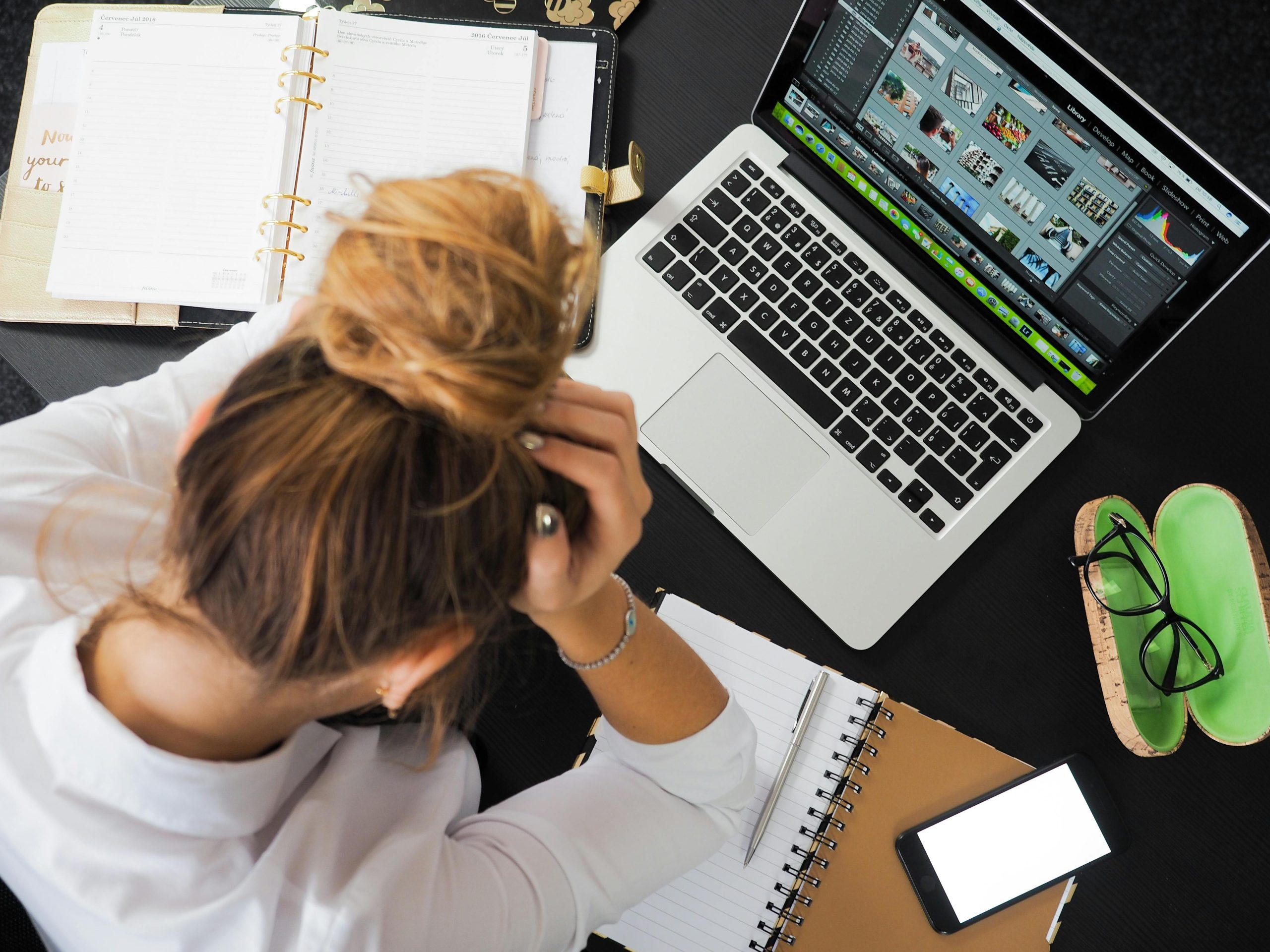 Mujer con estrés laboral buscando estrategias en computadora